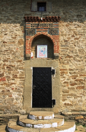 Intrarea în biserică evidenţiată de un element decorativ cu detalii din ceramică glazurată