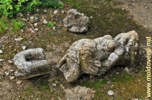 Fragmente ale statuii din piatră a sirenei în desişul havuzului principal al conacului